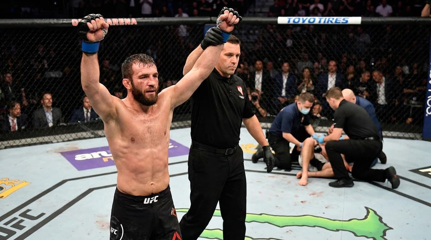 A mixed martial arts fighter celebrates a knockout victory inside the octagon