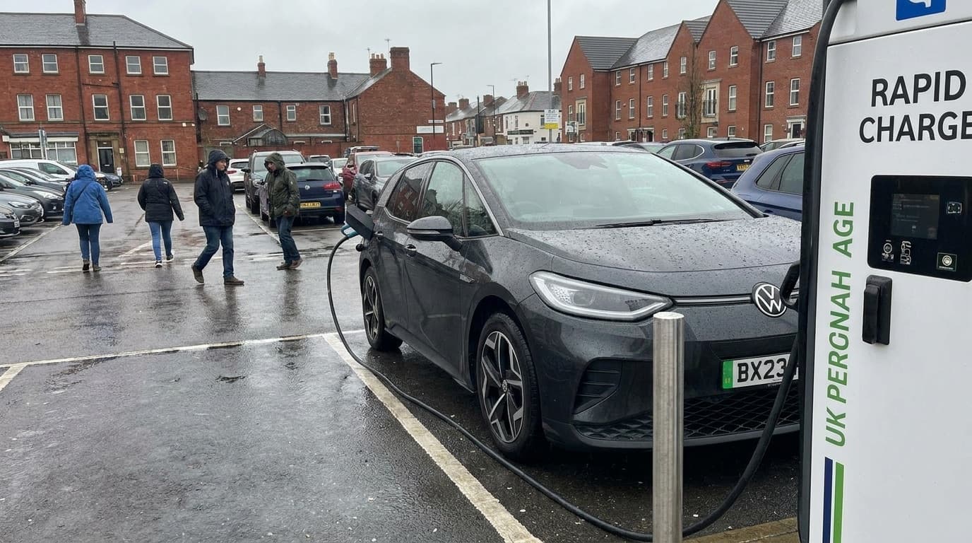 Electric car plugged into a public rapid charging point in a UK car park